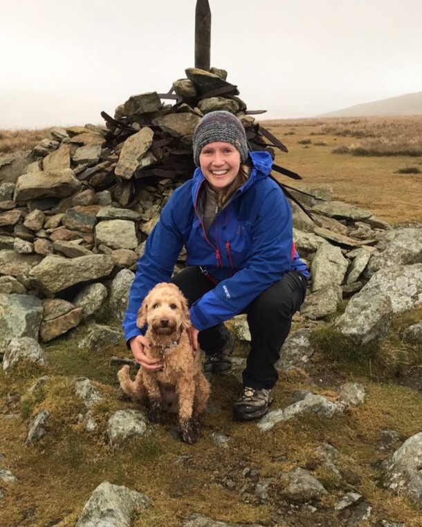 Emma with her dog at the top of a mountain